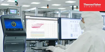 Researcher in PPE working at a computer