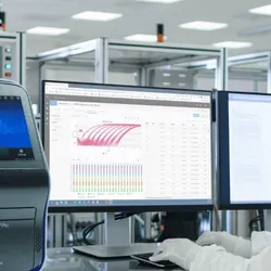 Researcher in PPE working at a computer