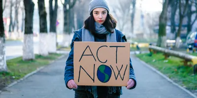 Young women activist holding a sign protesting against climate change