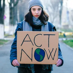 Young women activist holding a sign protesting against climate change