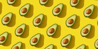 Avacado halves on a yellow background