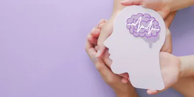 Hands holding encephalography brain paper cutout