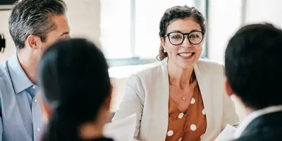 Woman sits in a meeting with colleagues