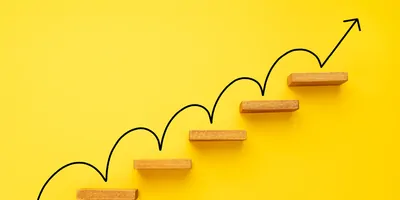 Rising arrow on staircase on yellow background