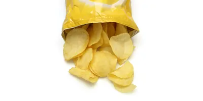 Bag of potato chips lies open on a table
