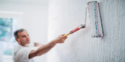 Painter man at work with a paint roller
