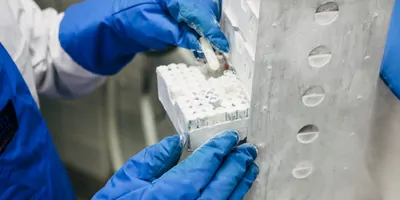 a scientist putting vials into a cold storage unit