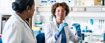 Young scientist discussing with colleague in lab