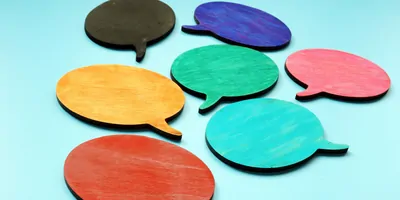 Communication concept with wooden speech bubbles of differing colors