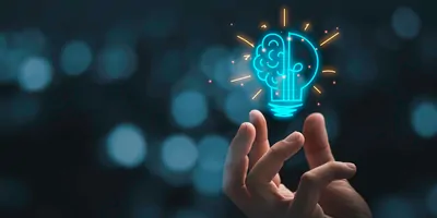 Hand holding a holographic lightbulb indicating innovation