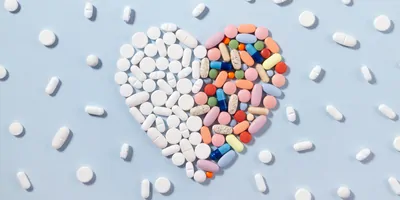 Pills pilled in a heart shape on a light blue background