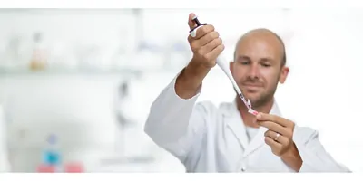 Male scientist using pipette