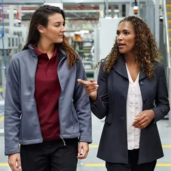 Businesswomen walk through a manufacturing facility talking
