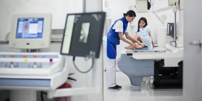 Technician taking an X-ray of a young girl