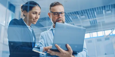 Two researchers look at a laptop in the lab