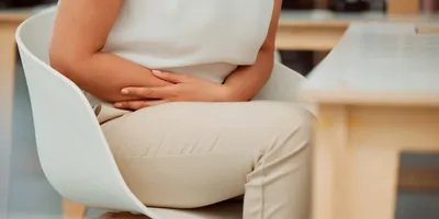 women suffering stomach pain in the office