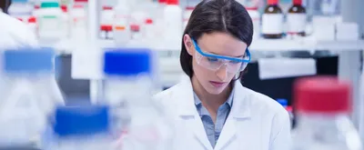 Female chemist wearing safety glasses and using tablet pc in lab