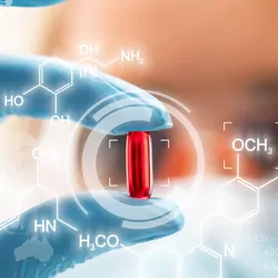 Woman wearing PPE and gloves holding a pill with holigraphic chemical symbols around it