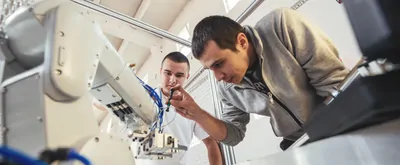 Engineers examining a piece of lab robotic equipment