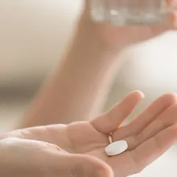 Person getting ready to take a pain reliever pill
