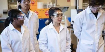 Students in lab coats and safety goggles