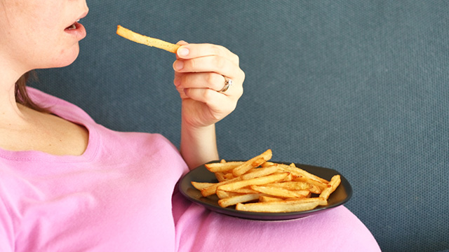 pregnant woman eating French fries