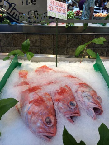 Fish labeled as red snapper are seen on ice in a fish market