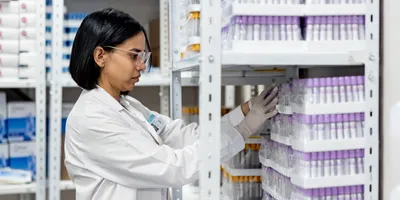Latin American female doctor organizing blood collection tubes in the storage room at the laboratory