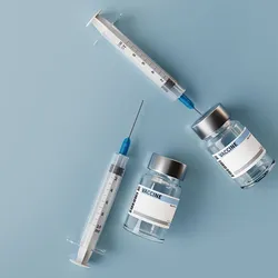 Vaccine vials sit on a blue background