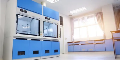 Iamge of a blue and white fume hood in amodern lab. the lab is spacious and illustrates the impoirtance of proper fume hood placement