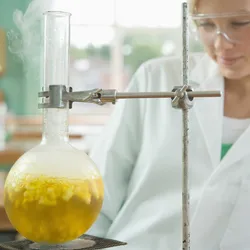 Woman lab technician heating a flask of yellow liquid using bioling chips