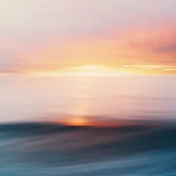 Landscape photo of the sun setting over a misty ocean