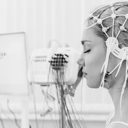 Neurotechnology progress represented by EEG sensors on the head of a young female patient for brain testing in a medical center.