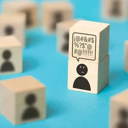 image of blocks ona blue background with figures on them - one image appears angry illustrating the concept of employee negativity