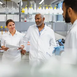 group of scientists in the process of holding a meeting in the lab