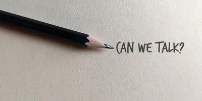 image opf a pencil on parchment paper with the text "Can we Talk?" represting the idea of effectively communicating bad news
