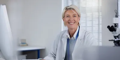image of an approachable and effective manager sitting behind a desk smiling welcomingly