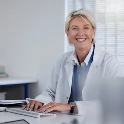 image of an approachable and effective manager sitting behind a desk smiling welcomingly