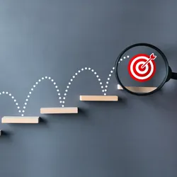 image of a red target bouncing up ascending shelves illustrating the concept of goal setting