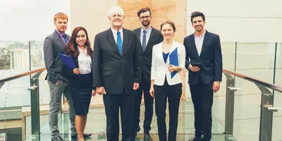 image of six mangers of different ages and genders standing in a group illustrating the concept of delivering six different leadership styles