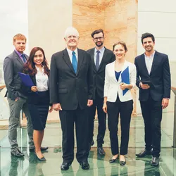 image of six mangers of different ages and genders standing in a group illustrating the concept of delivering six different leadership styles