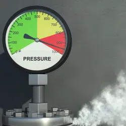 a pressure gauge with the needed in the red area on top of a smoking cannister illustrating the idea of working safely with pressure and vacuum systems