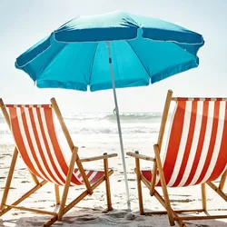 two res and white beach chairs inder a blue umbrella on the beach showing the importance of taking vacations to recharge