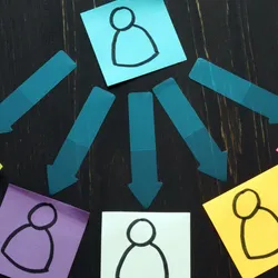 Colorful sticky notes with simple human icons connected by arrows, representing effective delegation and task distribution