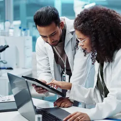 Lab manager reviews results on an iPad with a lab technician