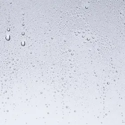 Water droplets on a water-repellent glass surface, demonstrating advanced materials science technology.