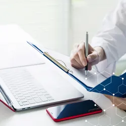 lab worker writing in a notebook next to a laptop illustrating the concept of paper-based managment versus a LIMS