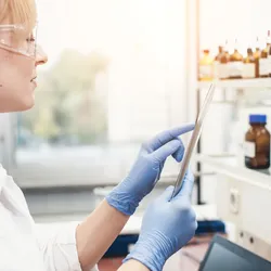 scientist with tablet and reagents engaged in laboratory inventory management