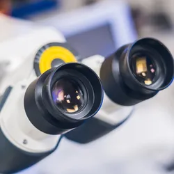 close up of two microscope eyepieces suggesting a choice betwen confocal and fluorescene microscopy