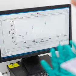 lab technician analyzing a screen with spectroscopy data illustrating the importance of atomic absorption spectroscopy and inductively coupled plasma icp spectroscopy in the modern lab